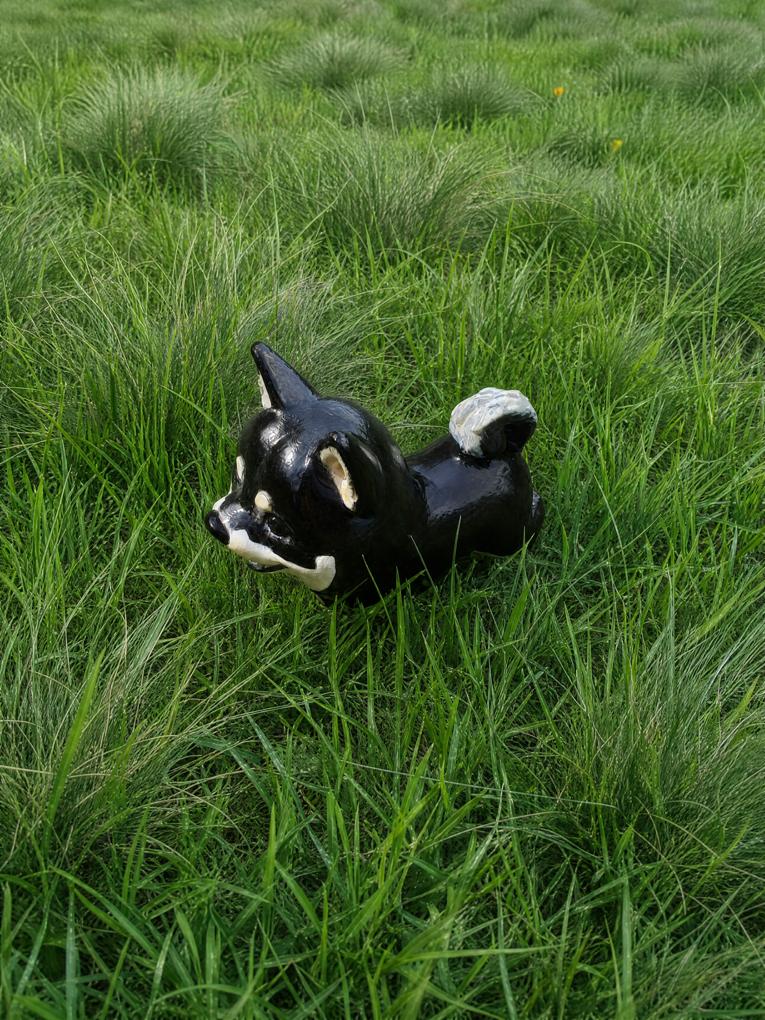 Custom dog figurine of a black Shiba Inu lying in the grass, top view