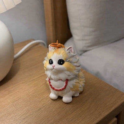 Hand-painted chibi figurine of the same calico cat on a nightstand