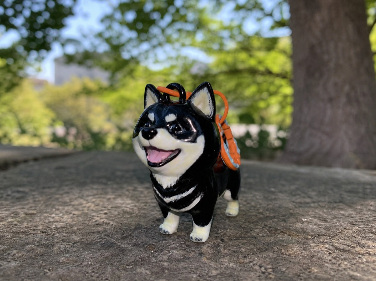Hand-painted chibi black shiba keychain standing outdoors, made from your pet's photos